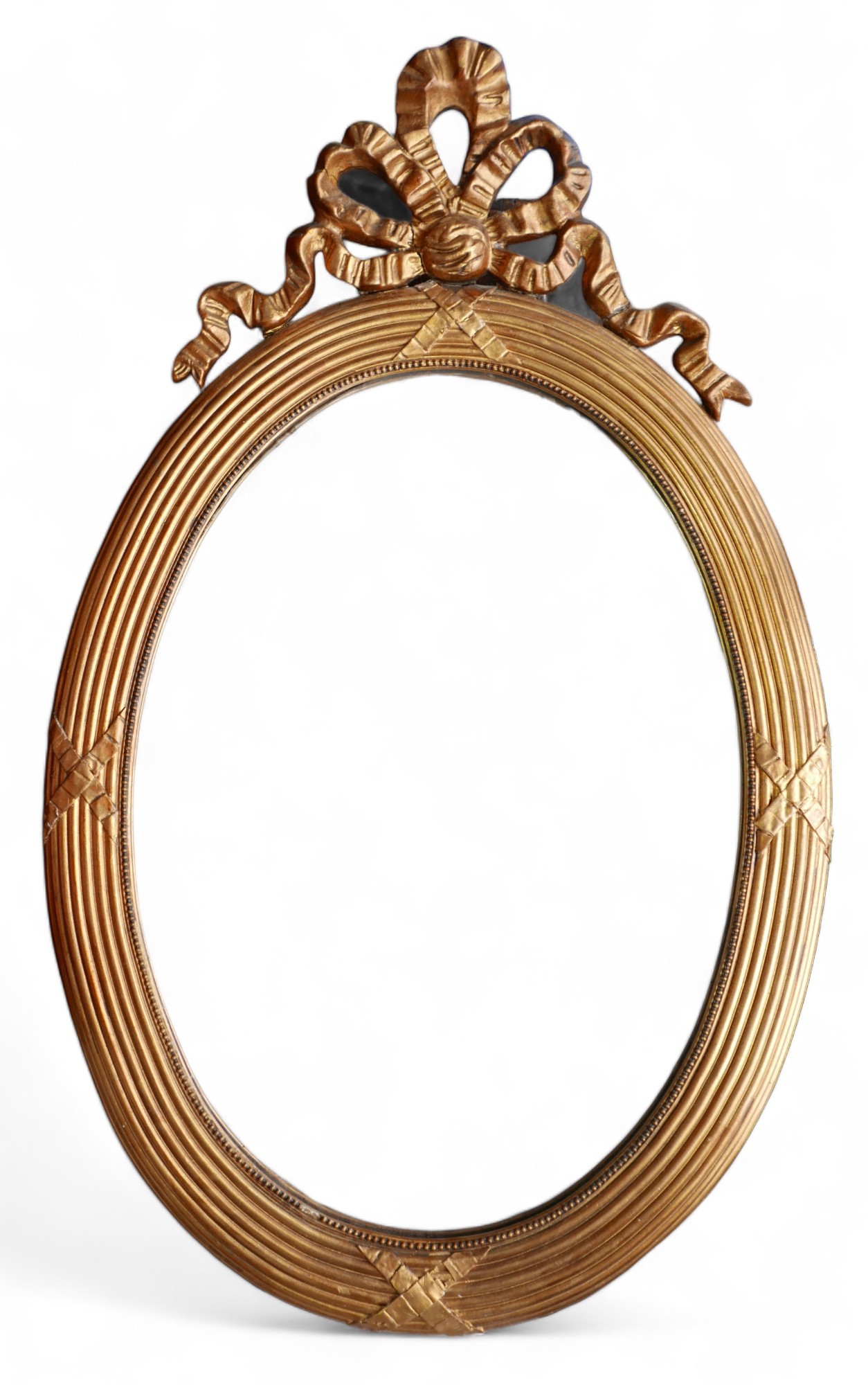 An oval gilt modern mirror, with ribbon top detailing.