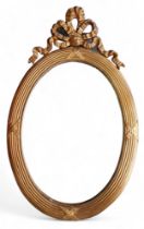 An oval gilt modern mirror, with ribbon top detailing.