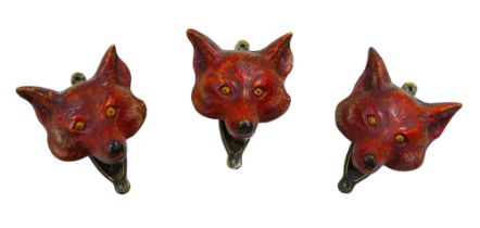 Three painted brass fox head door knockers, each 6 by 4.5 by 8cm high. (3)
