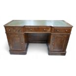 A late Victorian walnut veneered desk, green leather surface, three frieze drawers with turned