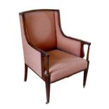 An Edwardian mahogany armchair, upholstered in a pink diamond patterned fabric, raised on tapering