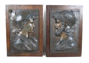 A pair of bronzed classical Greek plaques on oak boards 25cm by 35cm.