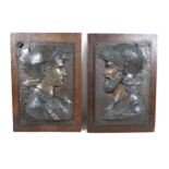 A pair of bronzed classical Greek plaques on oak boards 25cm by 35cm.