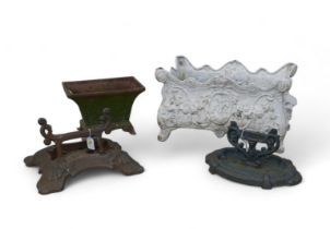 A group of cast iron garden objects, including a small rectangular iron planter, two cast iron