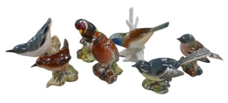 A group of seven small bird figurines, six Beswick plus one Karl Ens on a branch. (7)