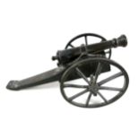 A miniature bronze canon, probably French 19th century, on wooden carriage with cast metal wheels,