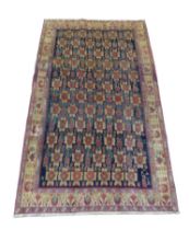 A Hamadan rug, on dark navy ground with repeat pattern to central panel, with large Caucasian border