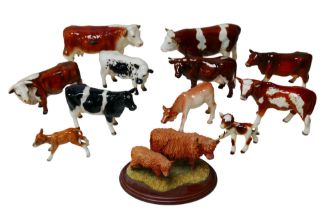 A collection of figurines modelled as cattle, including a Border Fine Arts figural group of Highland