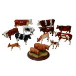 A collection of figurines modelled as cattle, including a Border Fine Arts figural group of Highland