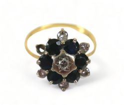 A 18ct diamond and sapphire flowerhead ring, (missing one diamond a/f), with six brilliant-cut