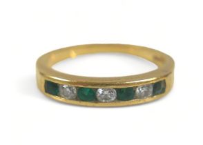 A seven-stone emerald and diamond ring, comprising three diamonds and four emeralds on 750 / 18ct