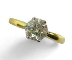 An 18ct yellow and white gold, diamond solitaire ring, the brilliant cut stone, 6.4 by 4.0mm,