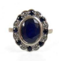 A 9ct yellow and white gold cluster ring, set with one central oval cut sapphire, approx 3.03ct,