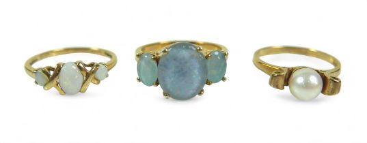 A group of three dress rings, comprising a three stone opal ring, largest stone 12.02 by 10.16mm,