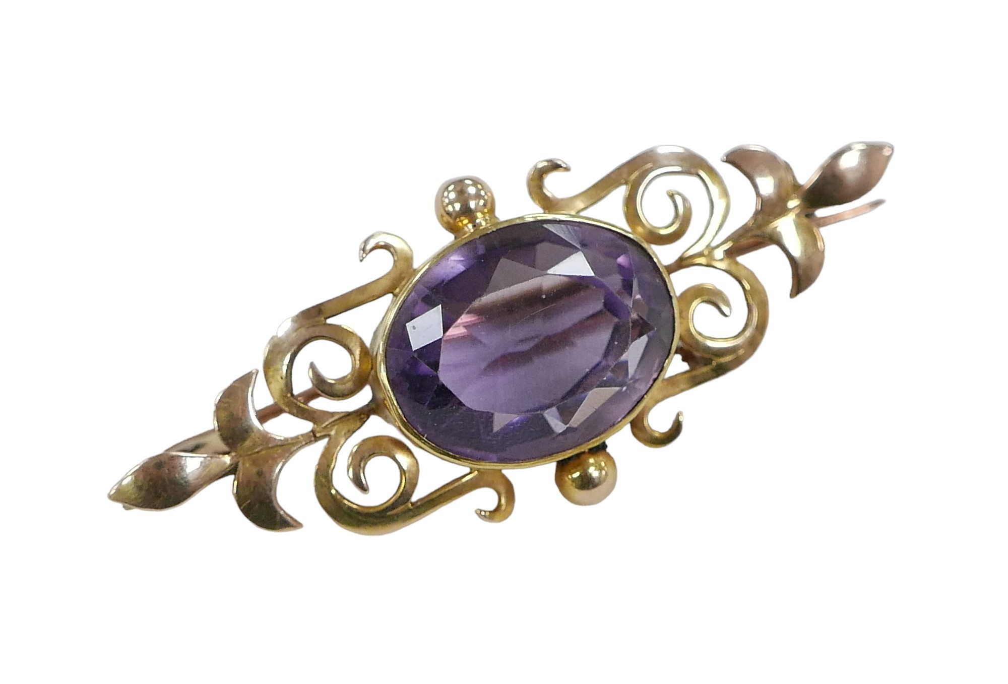 A yellow metal and amethyst bar brooch, the oval cut stone, 16 by 13mm, 7.8g, with fitted case.