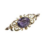 A yellow metal and amethyst bar brooch, the oval cut stone, 16 by 13mm, 7.8g, with fitted case.