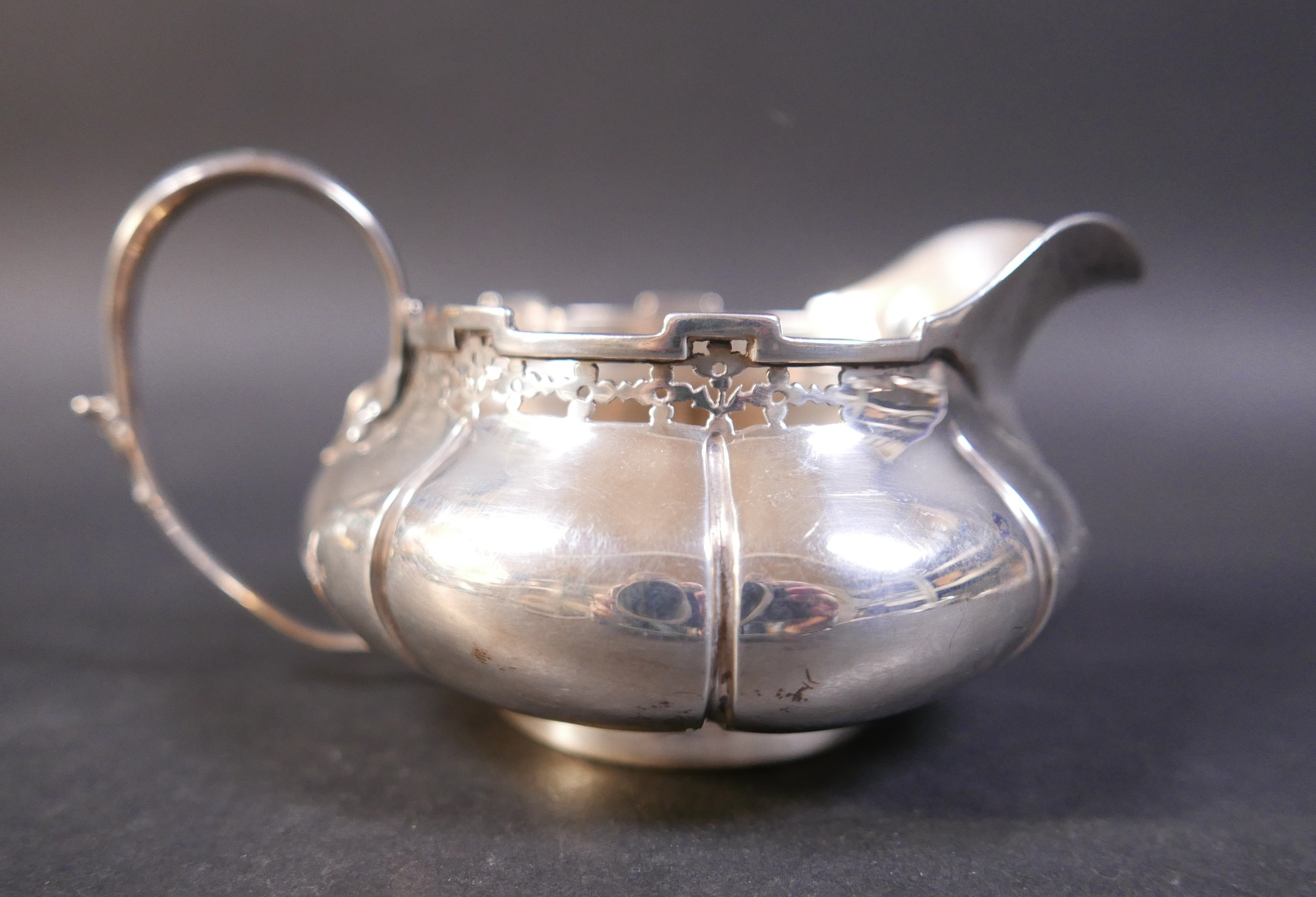 An Edwardian silver three piece tea set, decorated with a pierced rim, stamped 'Reg No 6136058', - Image 8 of 8