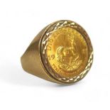 A 1981 1/10 Krugerrand (fine gold 1/10 oz) set in a gents 9ct gold ring, total weight 7g.