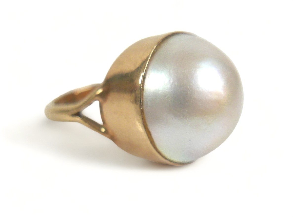 A 9ct gold ring set with a large cabochon pearl, approximately 15 mm diameter, size K, 6.9g.