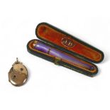 A mother of pearl 9ct banded cigarette holder and a 9ct locket, the holder hallmarked Birmingham