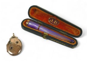 A mother of pearl 9ct banded cigarette holder and a 9ct locket, the holder hallmarked Birmingham