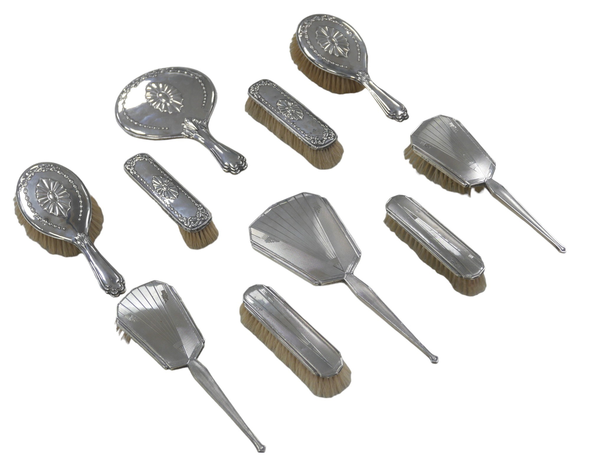 Two sets of silver backed dressing table brushes and hand mirrors, including a set of five, with