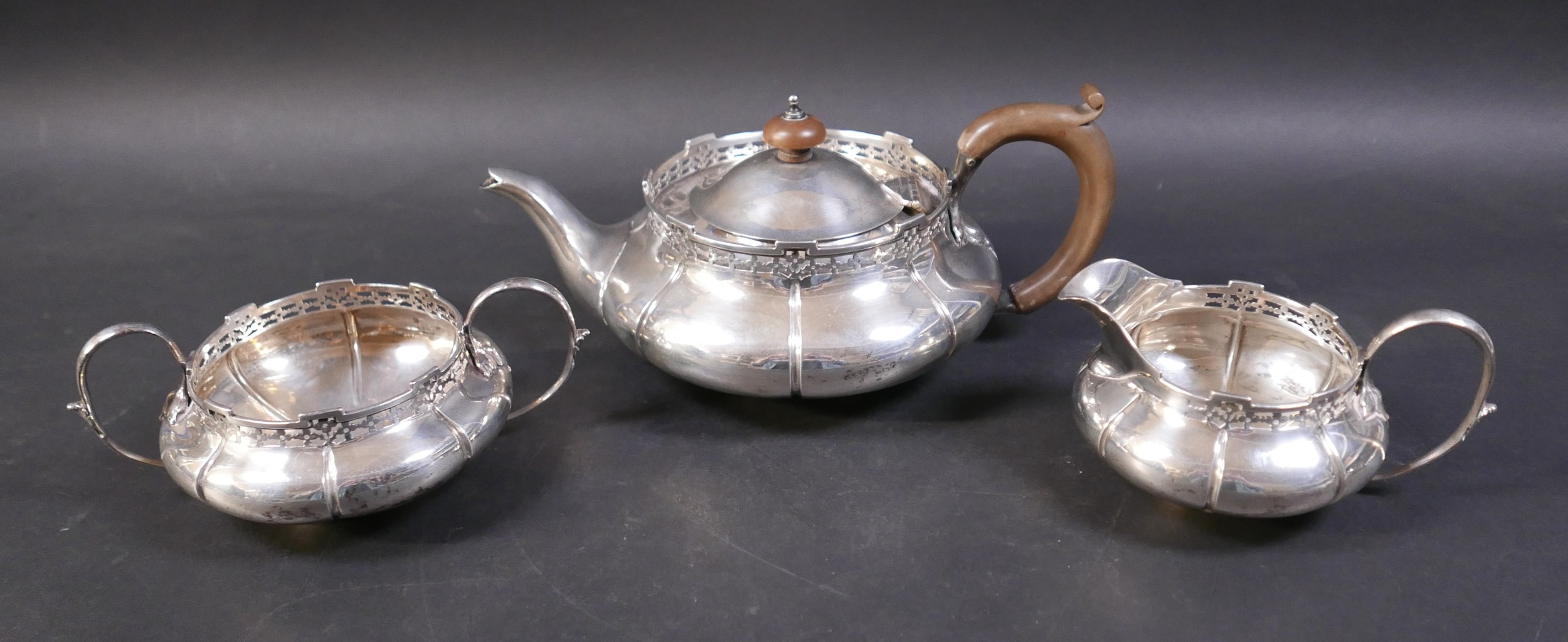 An Edwardian silver three piece tea set, decorated with a pierced rim, stamped 'Reg No 6136058',