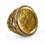 A George V gold half sovereign, 1914, set in a 9ct gold ring with open scrollwork shoulders, 10.1g.