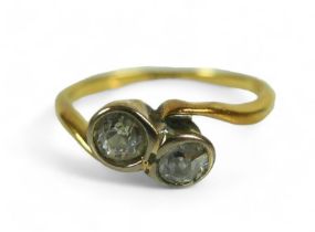 An 18ct yellow gold ring, set with two brilliant cut diamonds, each 3.5mm, 0.17ct, in crossover