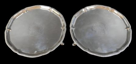 A pair of George III silver salver trays, with scalloped rim and gadrooned edge, raised on three