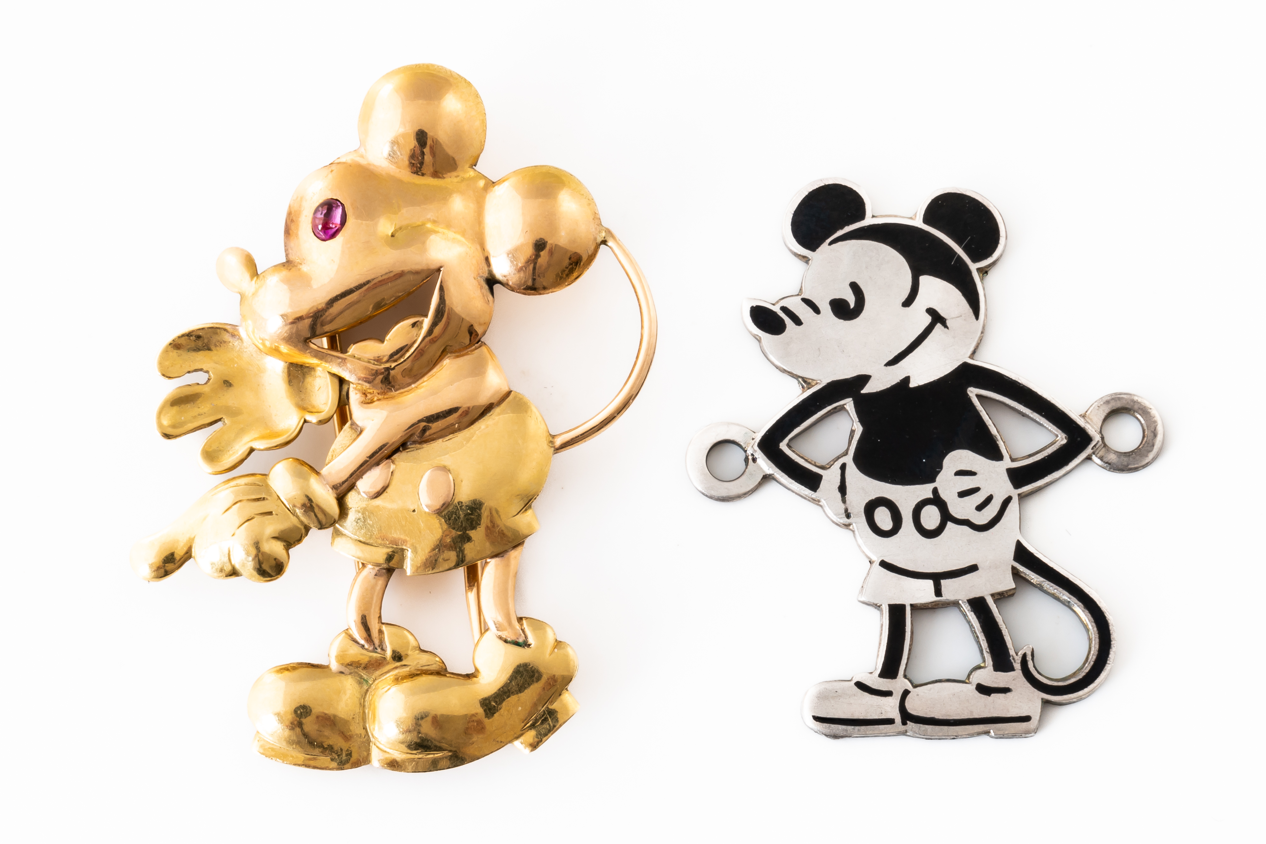 A GOLD MICKEY MOUSE BROOCH AND A SILVER AND ENAMEL MICKEY MOUSE BADGE (2)