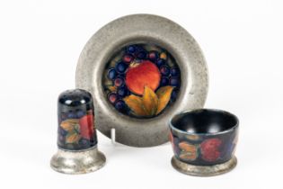 A MOORCROFT PEWTER MOUNTED SALT, PEPPER AND SMALL PLATE (3)