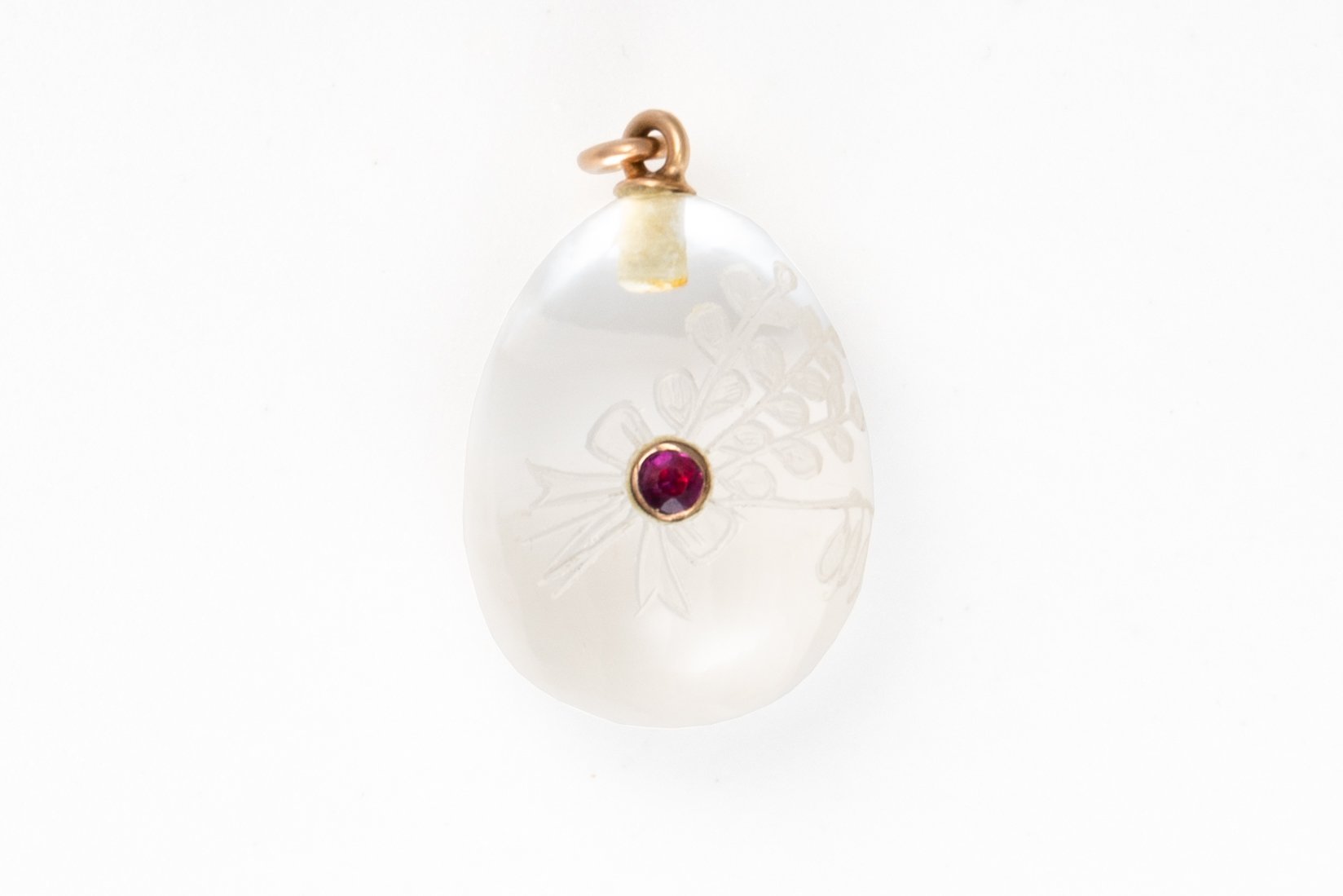 AN EARLY 20TH CENTURY ROCK CRYSTAL AND RUBY EGG CHARM