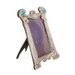 A SILVER AND ENAMEL MOUNTED SHAPED RECTANGULAR ART NOUVEAU PHOTOGRAPH FRAME