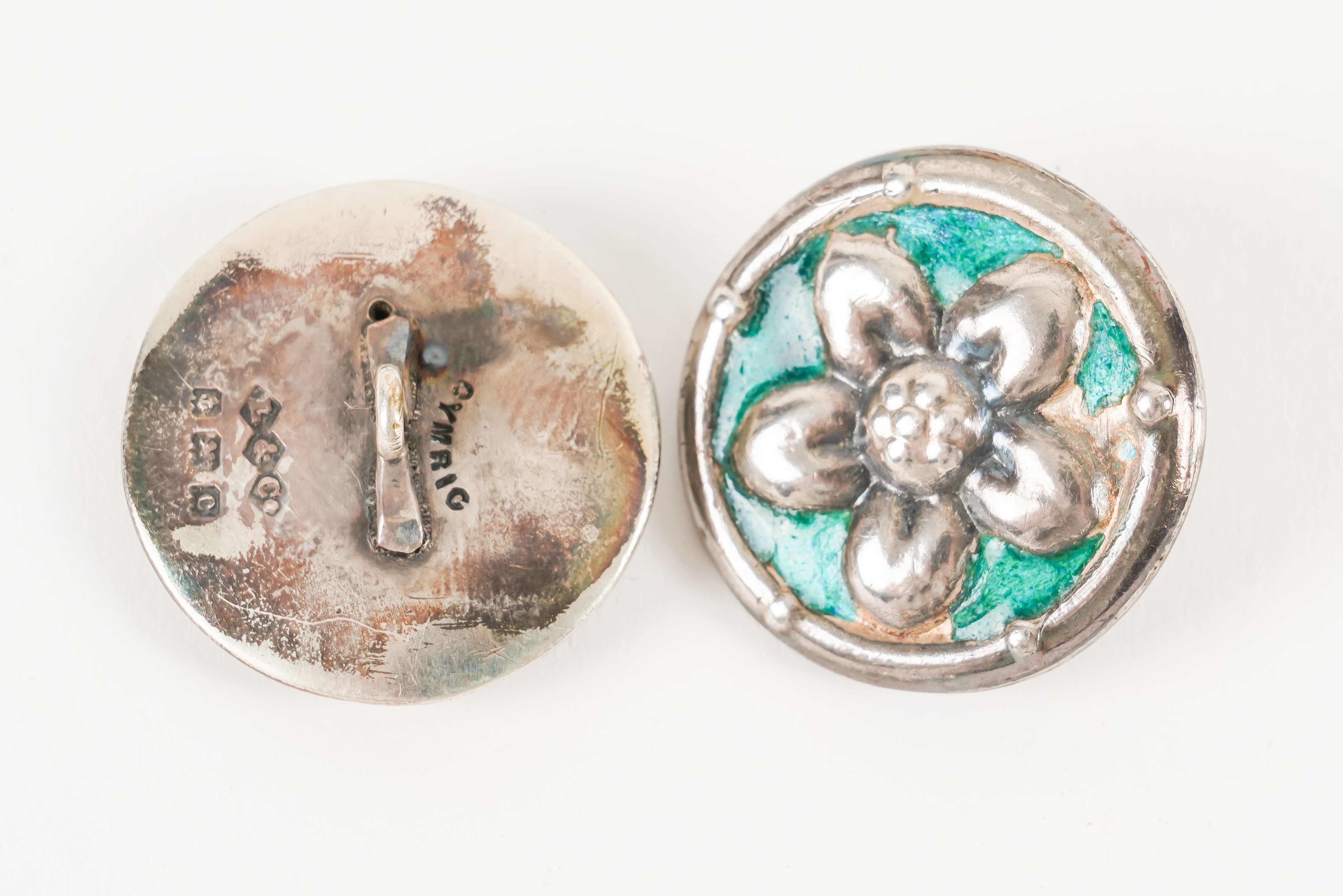 A SET OF SIX LIBERTY AND CO SILVER AND ENAMELLED BUTTONS (6)
