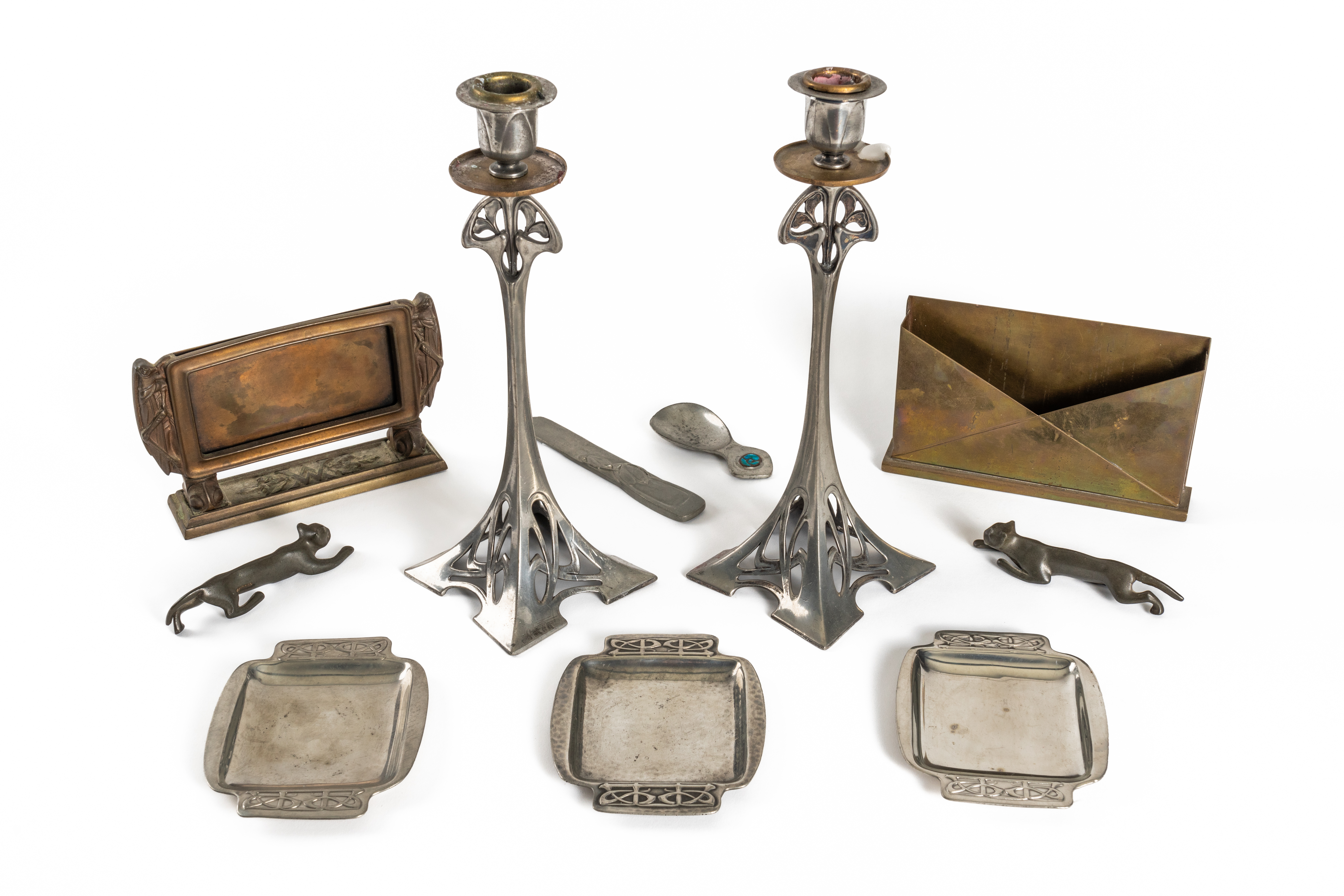 A PAIR OF WMF PEWTER ART NOUVEAU CANDLESTICKS AND THREE TUDRIC PEWTER PIN TRAYS AFTER A DESIGN...