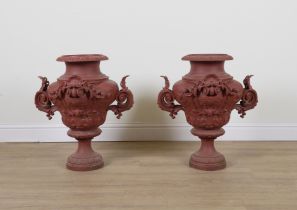 A PAIR OF BRICK RED PAINTED CAST IRON URNS (2)