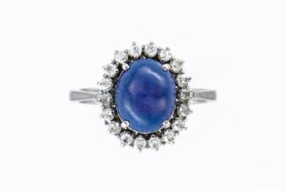 A SYNTHETIC STAR SAPPHIRE AND DIAMOND OVAL CLUSTER RING