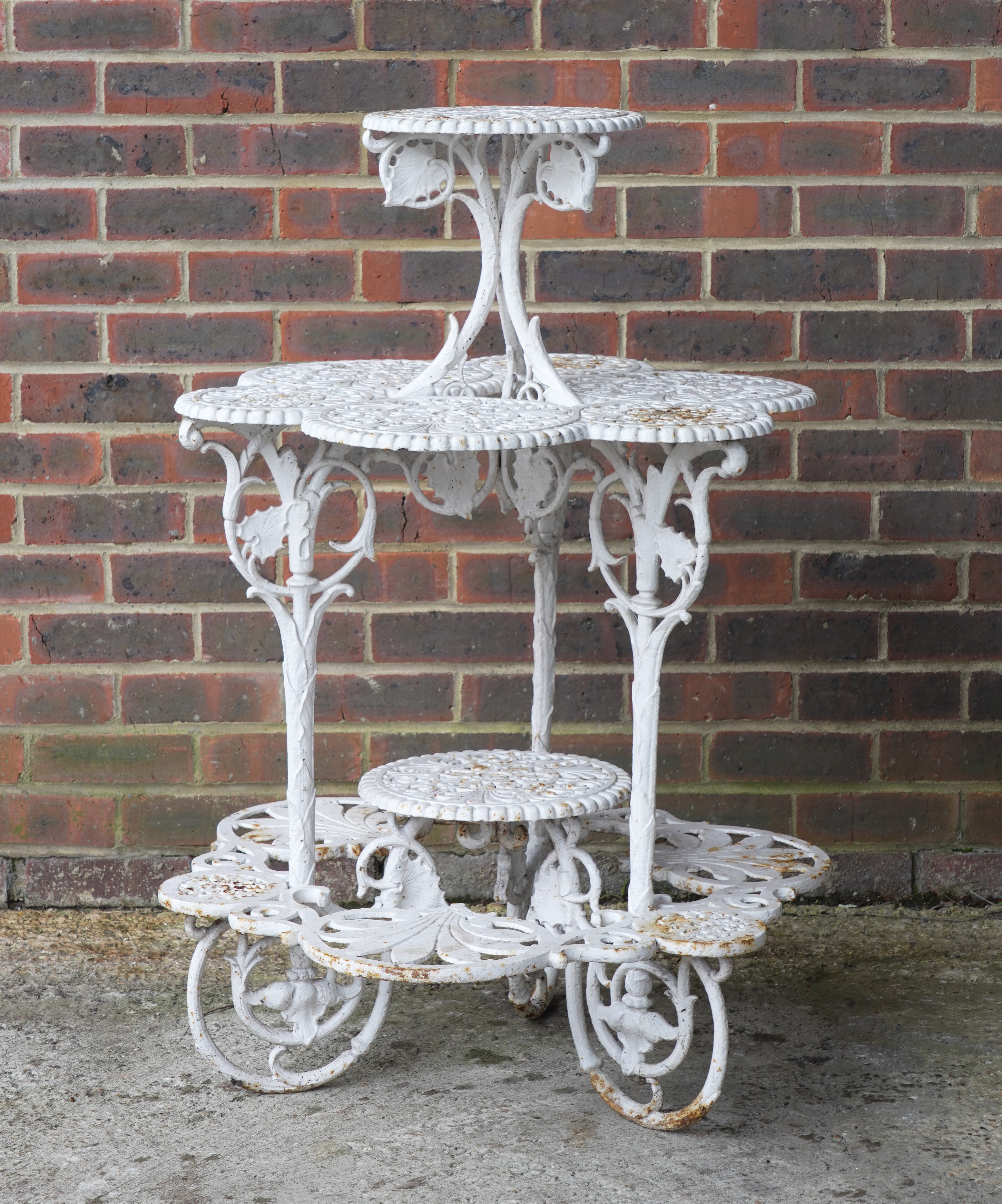 A VICTORIAN WHITE PAINTED CAST IRON FOUR TIER PLANT STAND