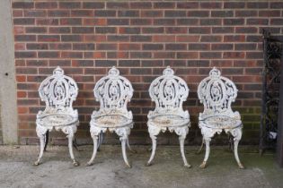 A SET OF FOUR VICTORIAN WHITE PAINTED CAST IRON GARDEN CHAIRS (4)