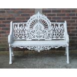 PIERCE WEXFORD; A WHITE PAINTED CAST IRON ARCHED BACK GARDEN BENCH