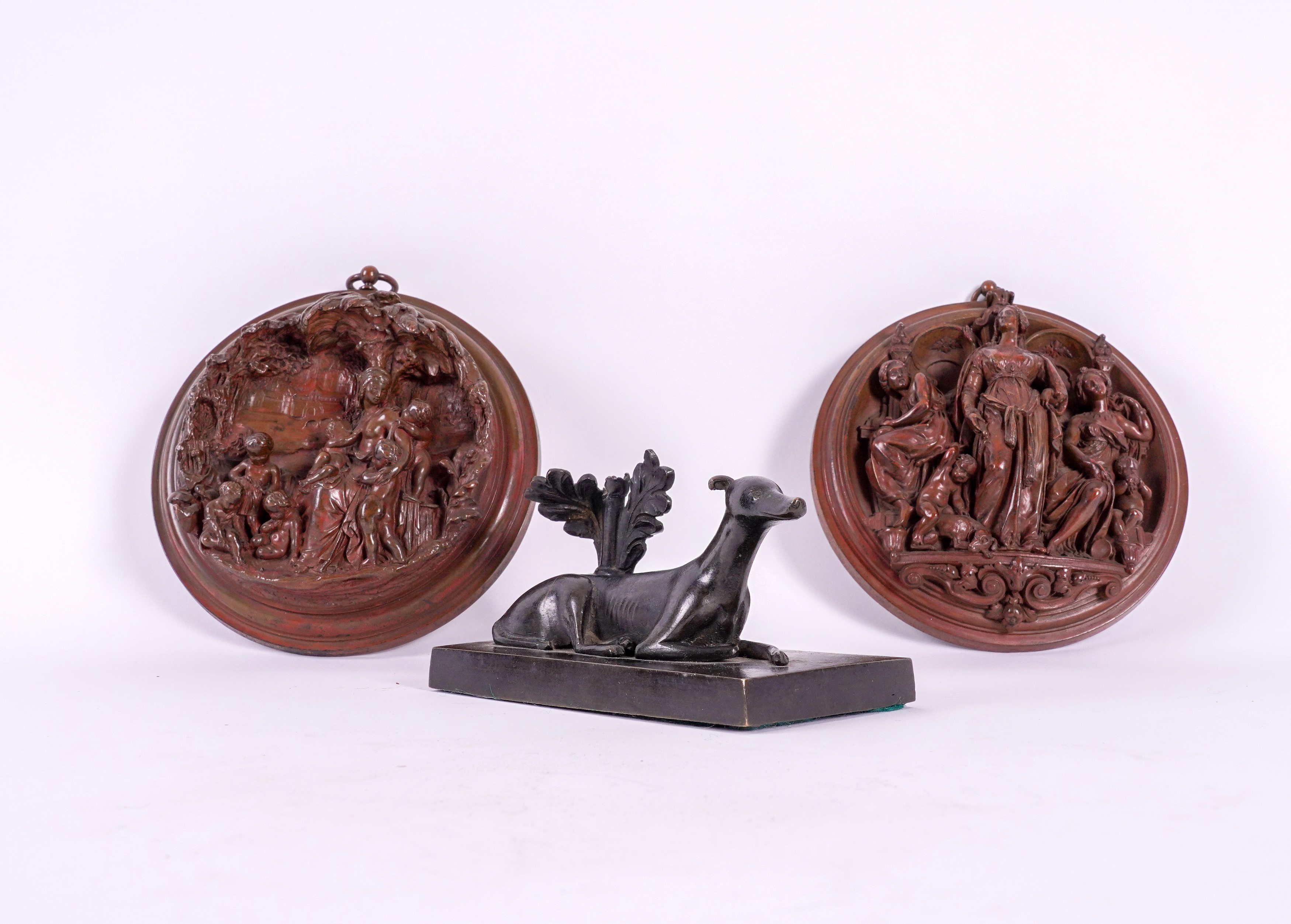 A REGENCY BRONZE GREYHOUND PAPERWEIGHT AND TWO ROUNDELS (3)