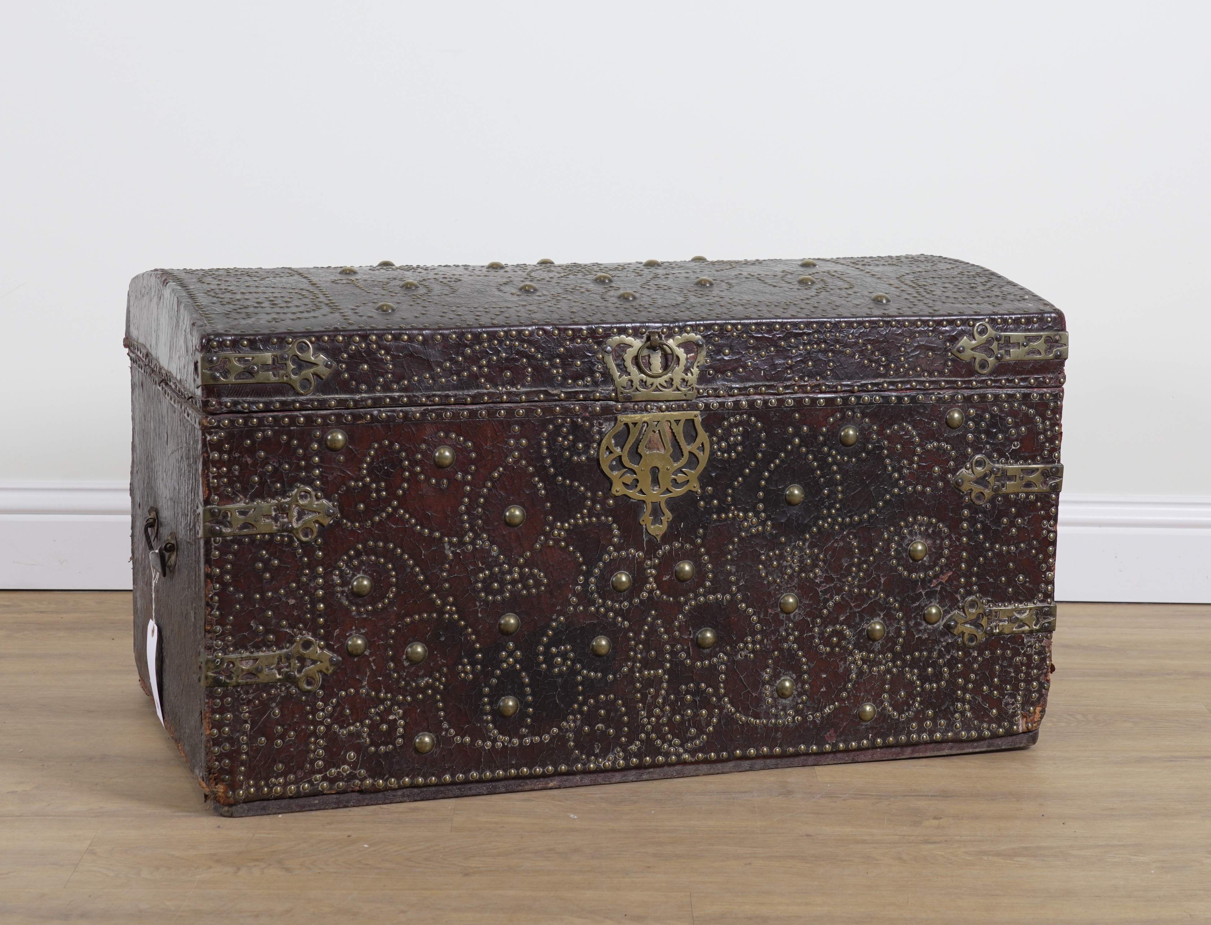 AN EARLY 18TH CENTURY BRASS STUDDED LEATHER VENEERED DOME TOPPED TRUNK