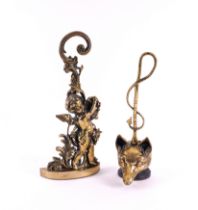 TWO ENGLISH PEERAGE BRASS DOOR STOPS: ONE MODELLED AS A BACCHANALIAN PUTTO, THE OTHER A FOX’S...