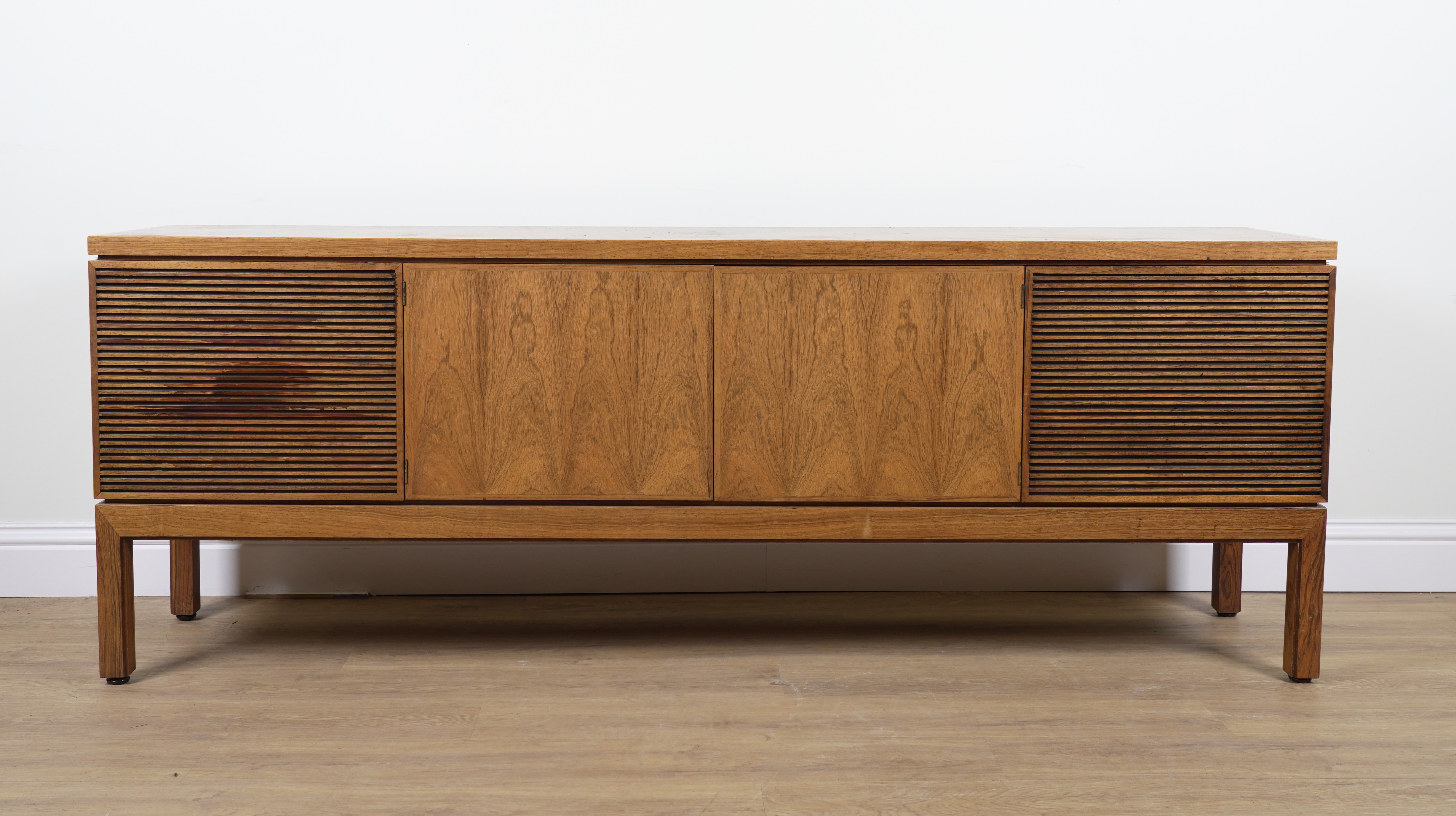 PROBABLY ARCHIE SHINE FOR HEALS FURNITURE; A MID 20TH CENTURY ROSEWOOD FOUR DOOR SIDEBOARD