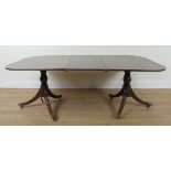 A GEORGE III STYLE MAHOGANY TWIN PILLAR EXTENDING DINING TABLE