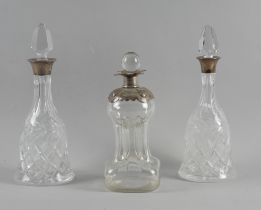 THREE SILVER MOUNTED GLASS DECANTERS (3)