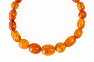 A STRING OF GRADUATED AMBER BEADS
