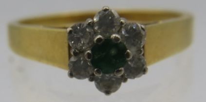 An 18ct yellow gold ring set with centre emerald with six surrounding diamonds, size O. Approx