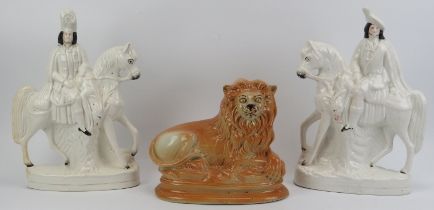 A large pair of Staffordshire ceramic equestrian figures and a recumbent lion. (3 item) Lion: 23.5